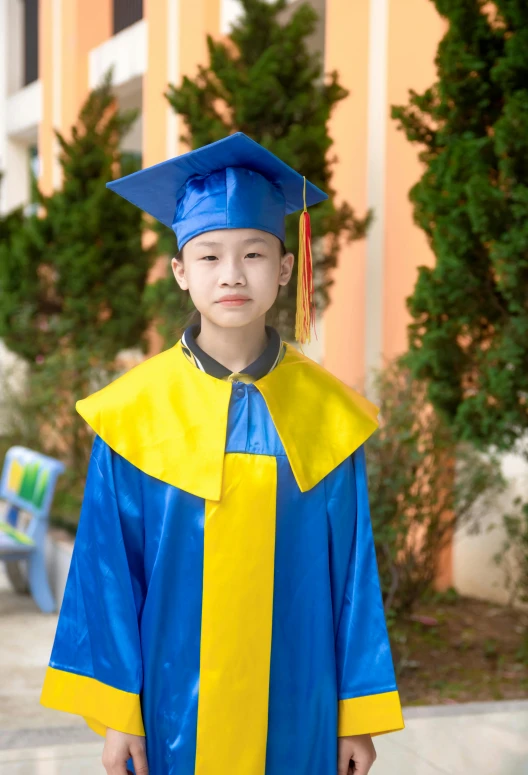 a boy in a blue graduation gown poses for the camera