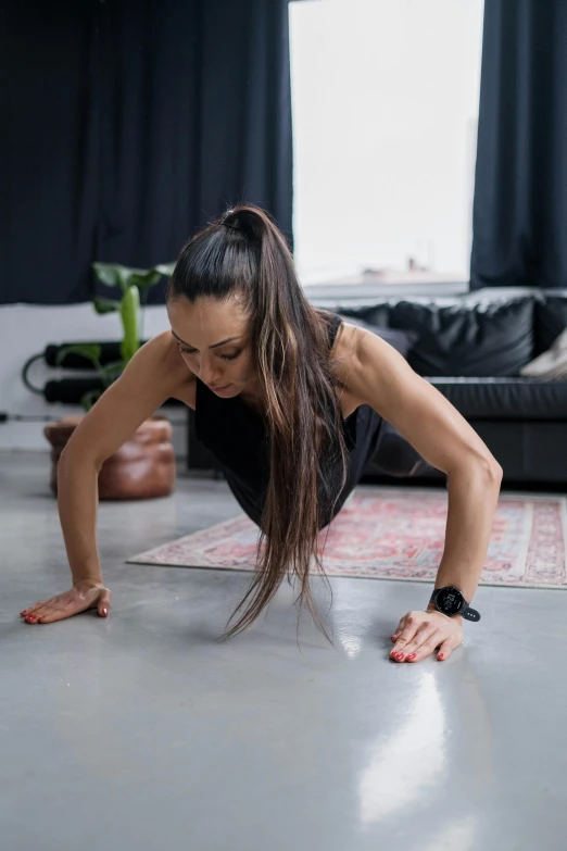 a woman stretches out on the floor while holding a tennis racket