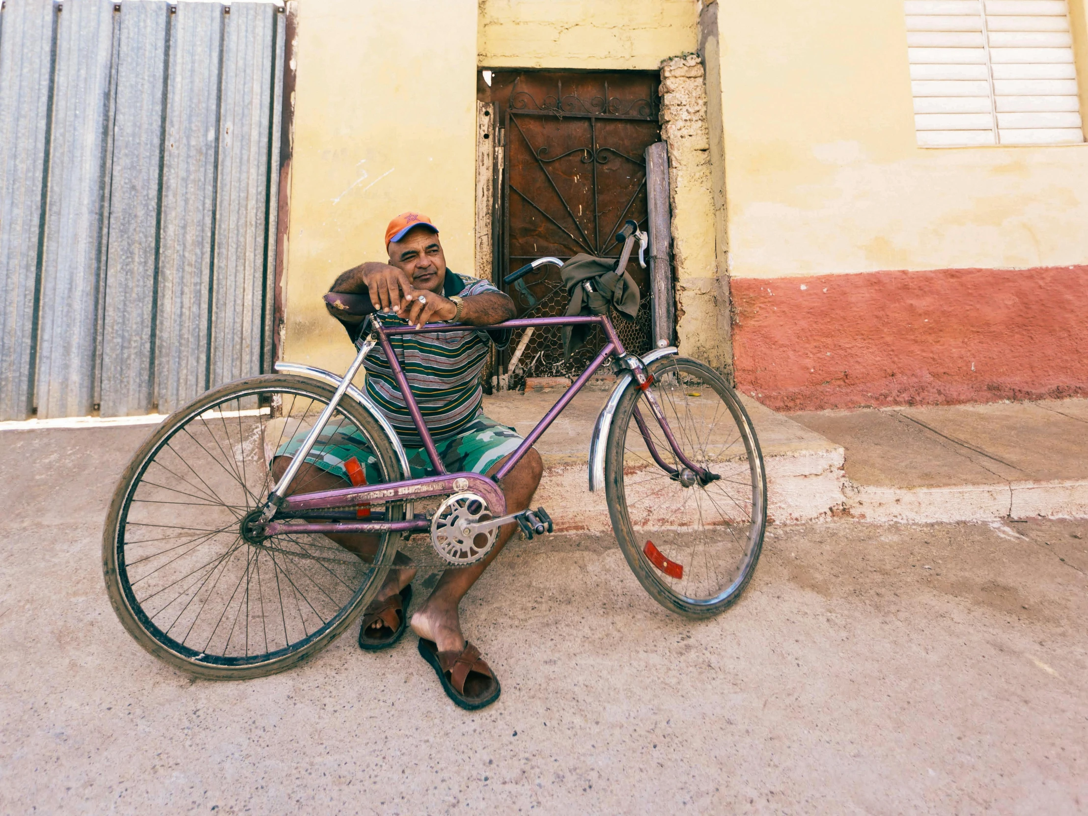 a man is sitting on the street with a bike