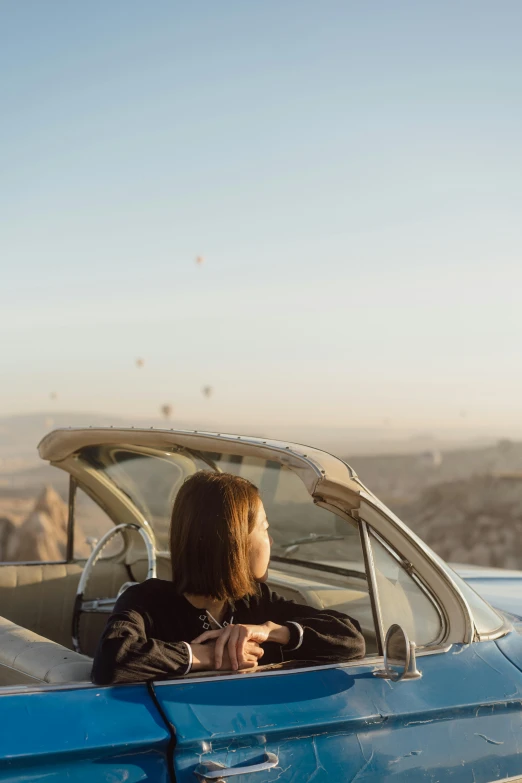 a woman in a car on the road, looking out from her window