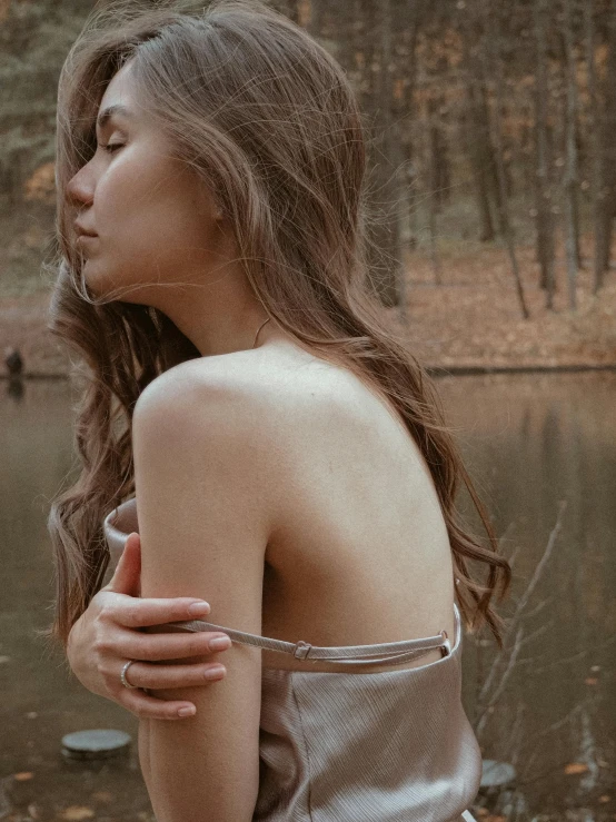 a woman standing in front of a body of water