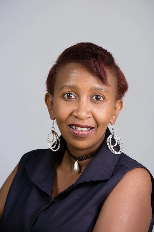 a woman with short hair wearing earrings, posing for a po