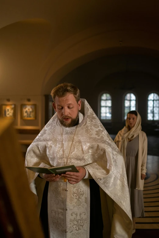 the priest reads his vows at the alter