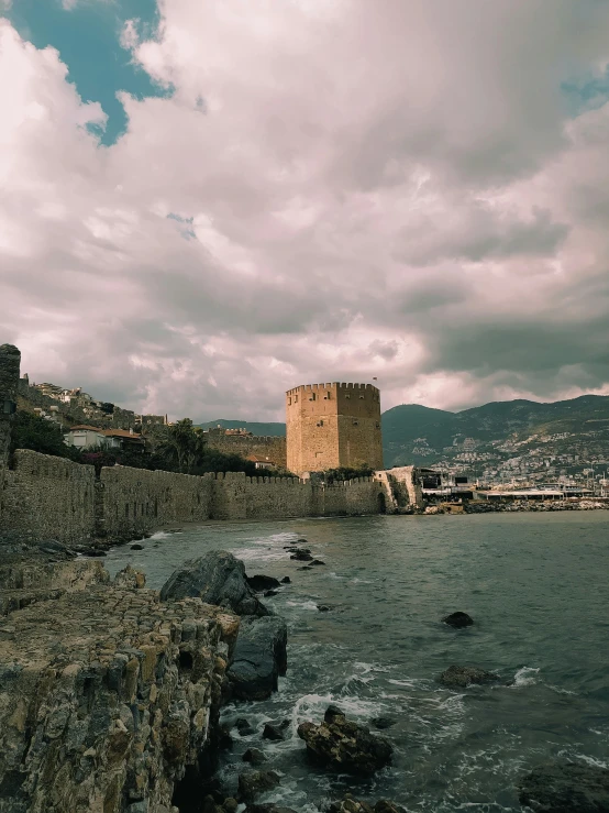 a castle tower is seen against the background of a harbor