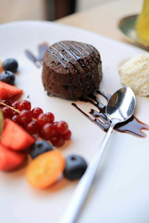 a white plate with a dessert and fruit on it