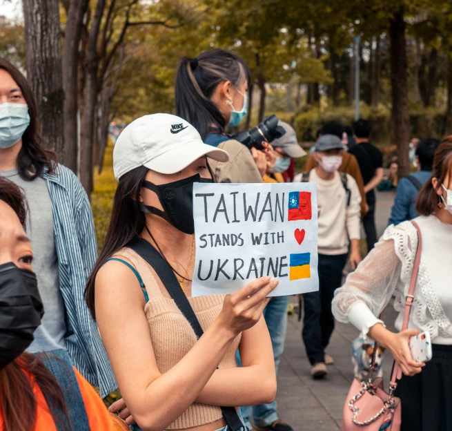 people are wearing face masks and holding signs with the words taiwan