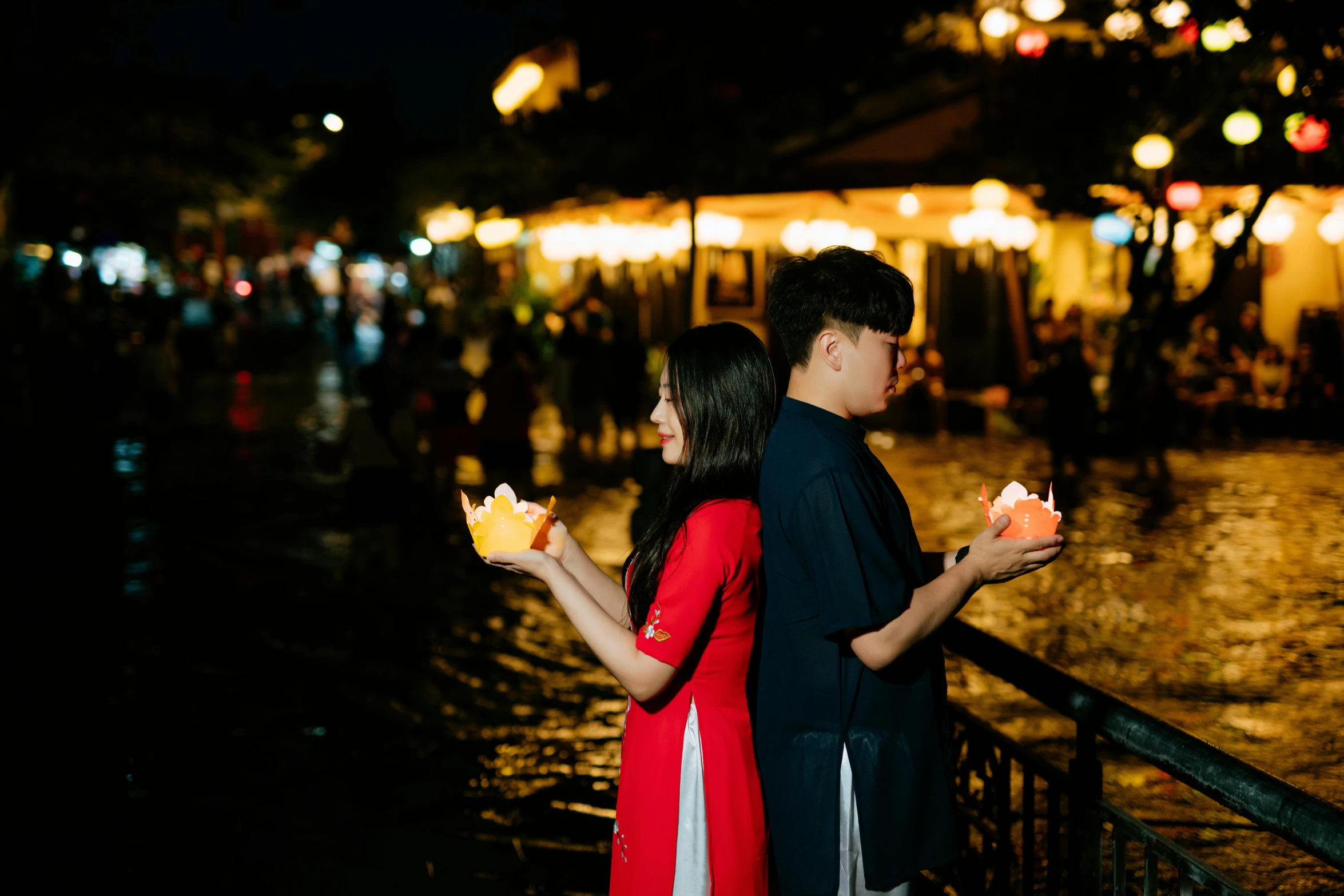 couple holding flower arrangements near an outdoor market