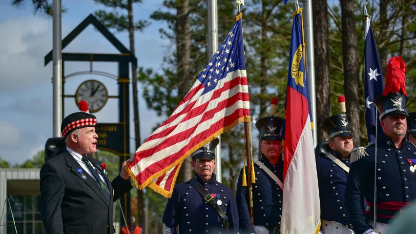 a group of men standing next to each other holding american flags