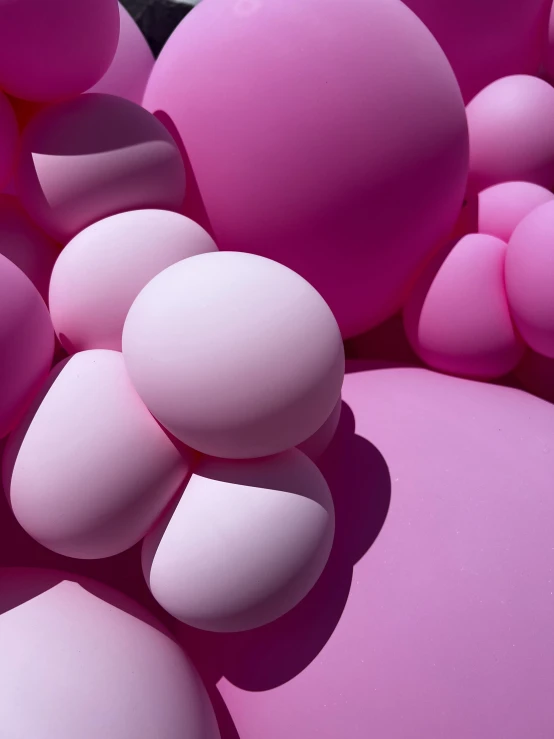 a large pile of pink balls are in the air