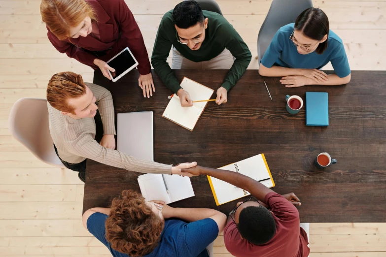 three people sitting at a table in an office