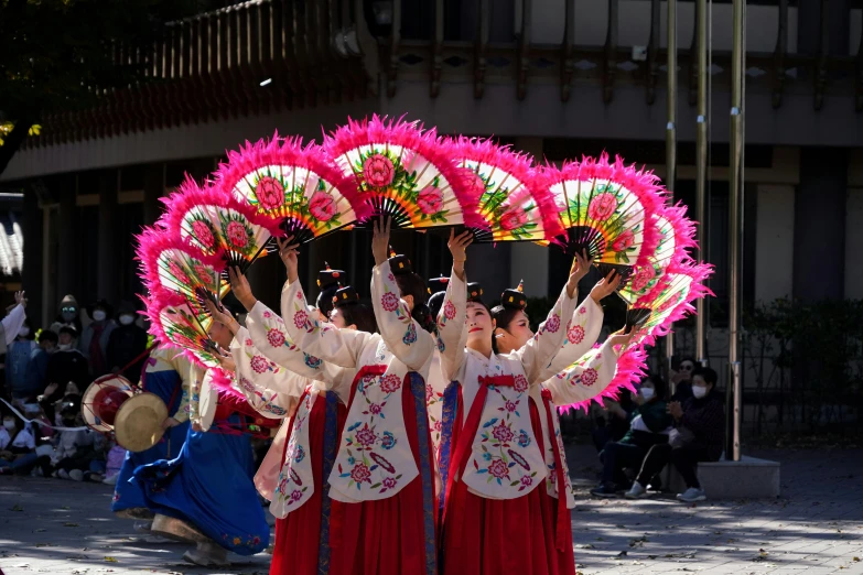 the two girls are wearing oriental garbs and holding umbrellas