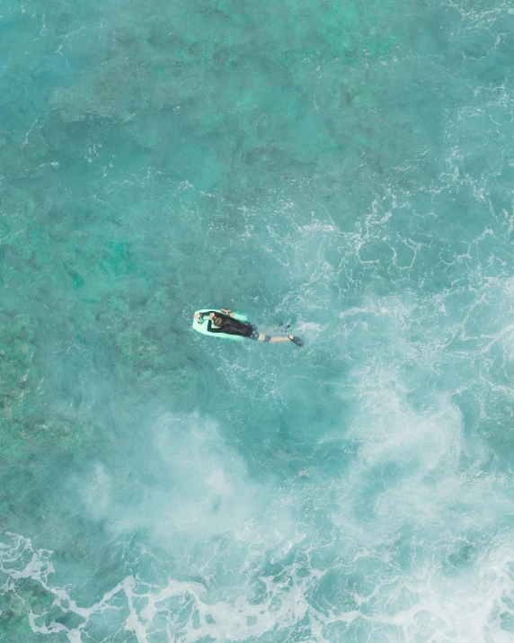 a person paddling a green surfboard in the ocean