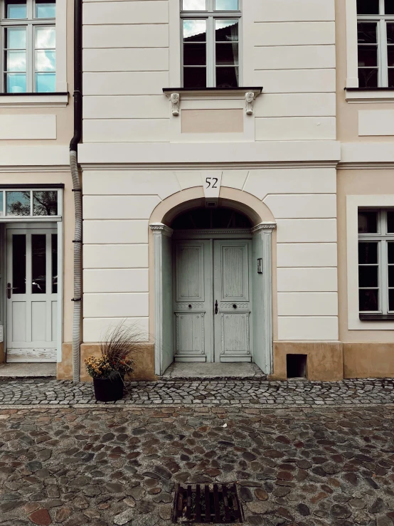 two tall white building with doors to windows