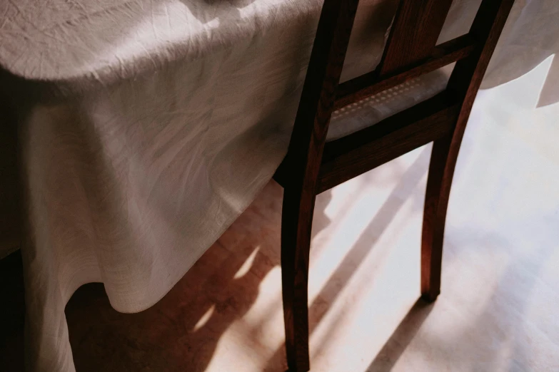 a table topped with a white tablecloth and a small cup