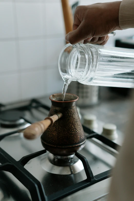 someone is pouring some water into an empty glass