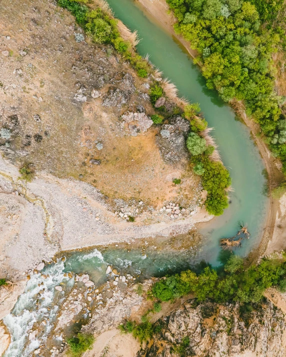 an aerial view of water running through a mountainous area