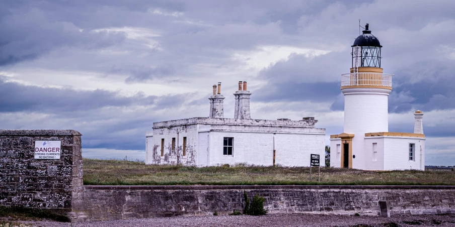 a very large building with a tower near a fence