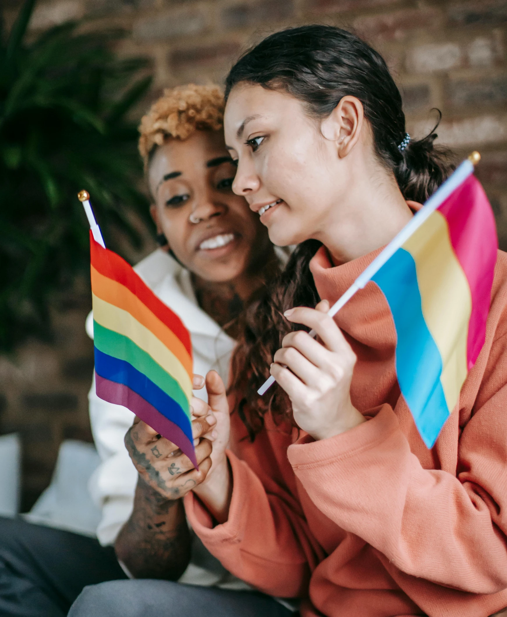 a couple of girls holding rainbow colored flags