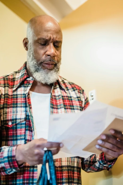 a man holding soing while wearing a plaid shirt