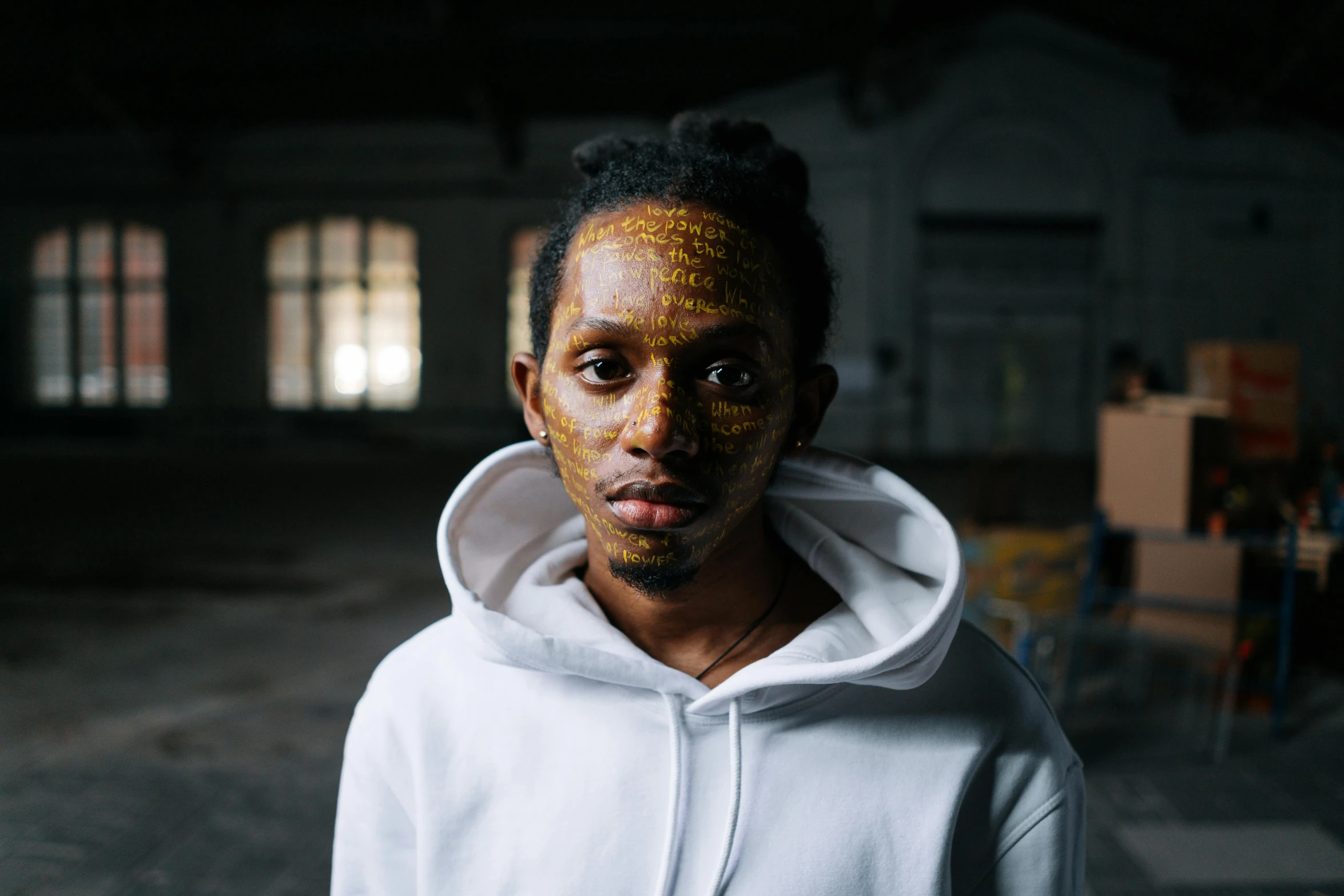 the man with golden paint on his face is wearing a hoodie