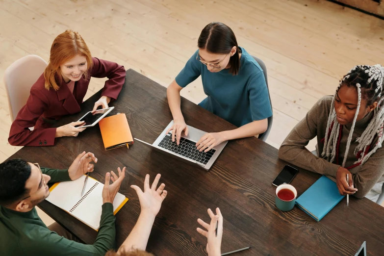 a group of people sitting around a wooden table