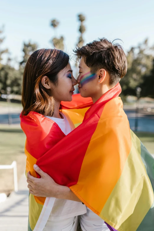 a man and woman kissing under a rainbow flag