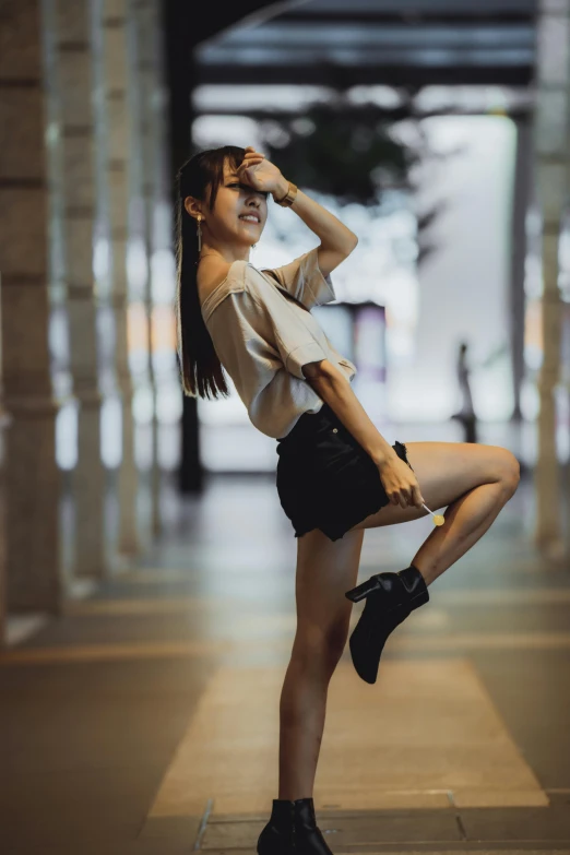 girl posing in heels and wearing shorts at night