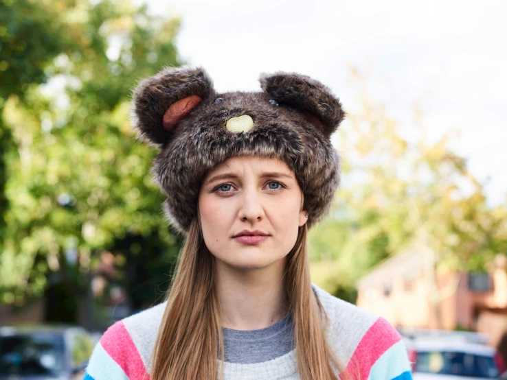 a girl with long hair and wearing a bear hat