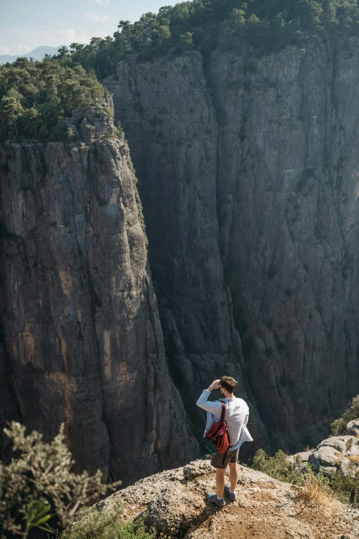 there is a woman standing at the top of a cliff