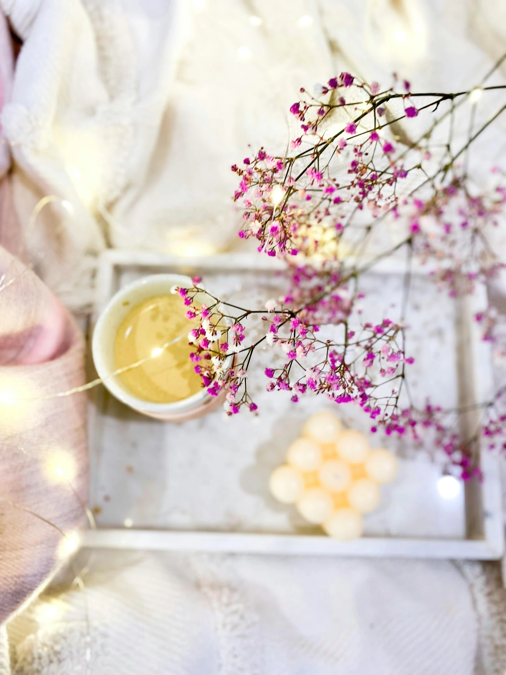 a small cup on a tray with flowers