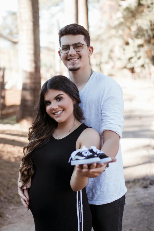 a couple holding up a camera in the woods