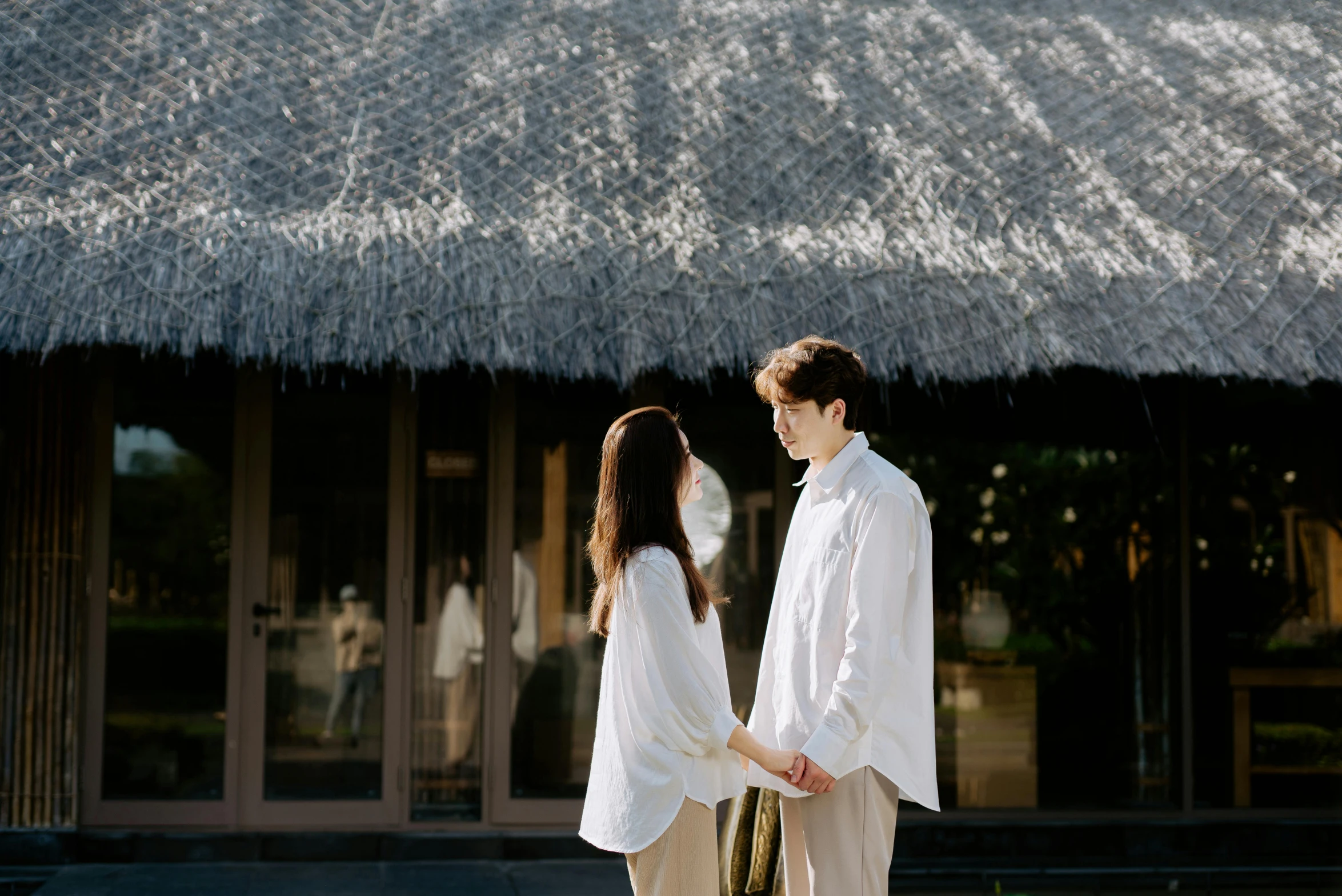 couple on vacation holding hands and walking towards front of building