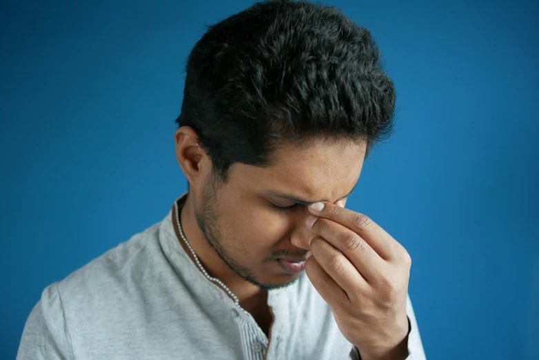 a man covers his eye with his hands