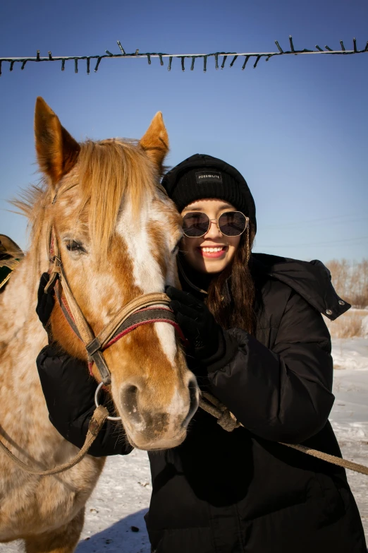 a woman is posing for a picture next to a horse