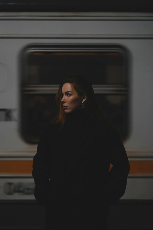 a woman standing next to a subway train