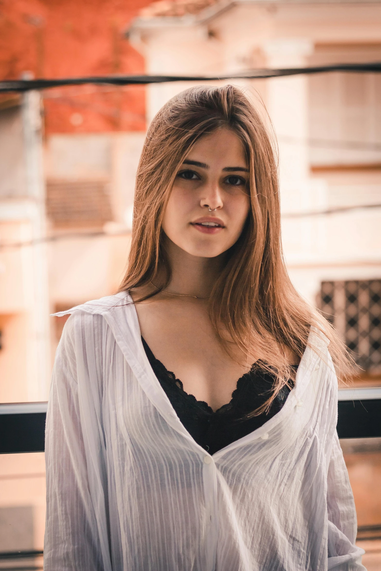 a women wearing a blouse standing in front of a brick wall