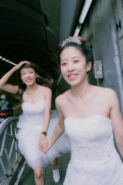 two women in dresses standing together smiling