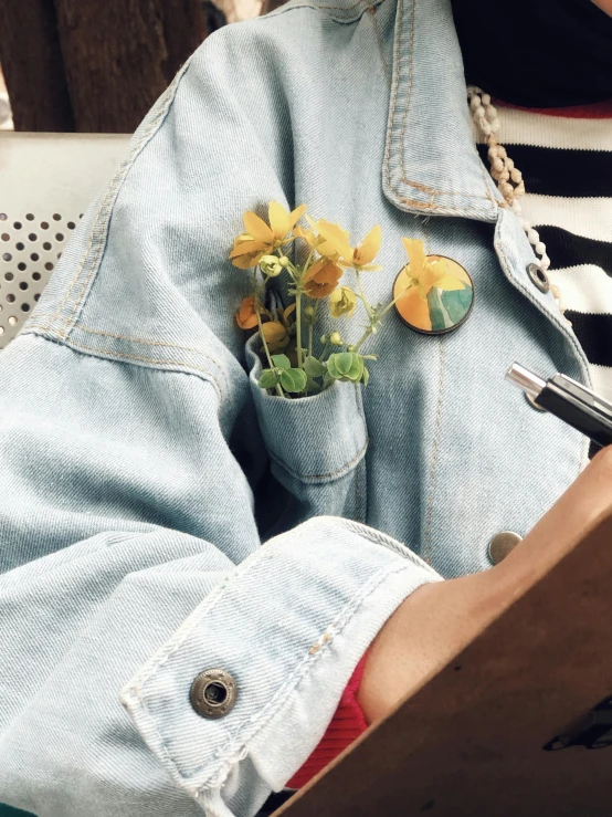 an image of a potted flower inside of a jean jacket