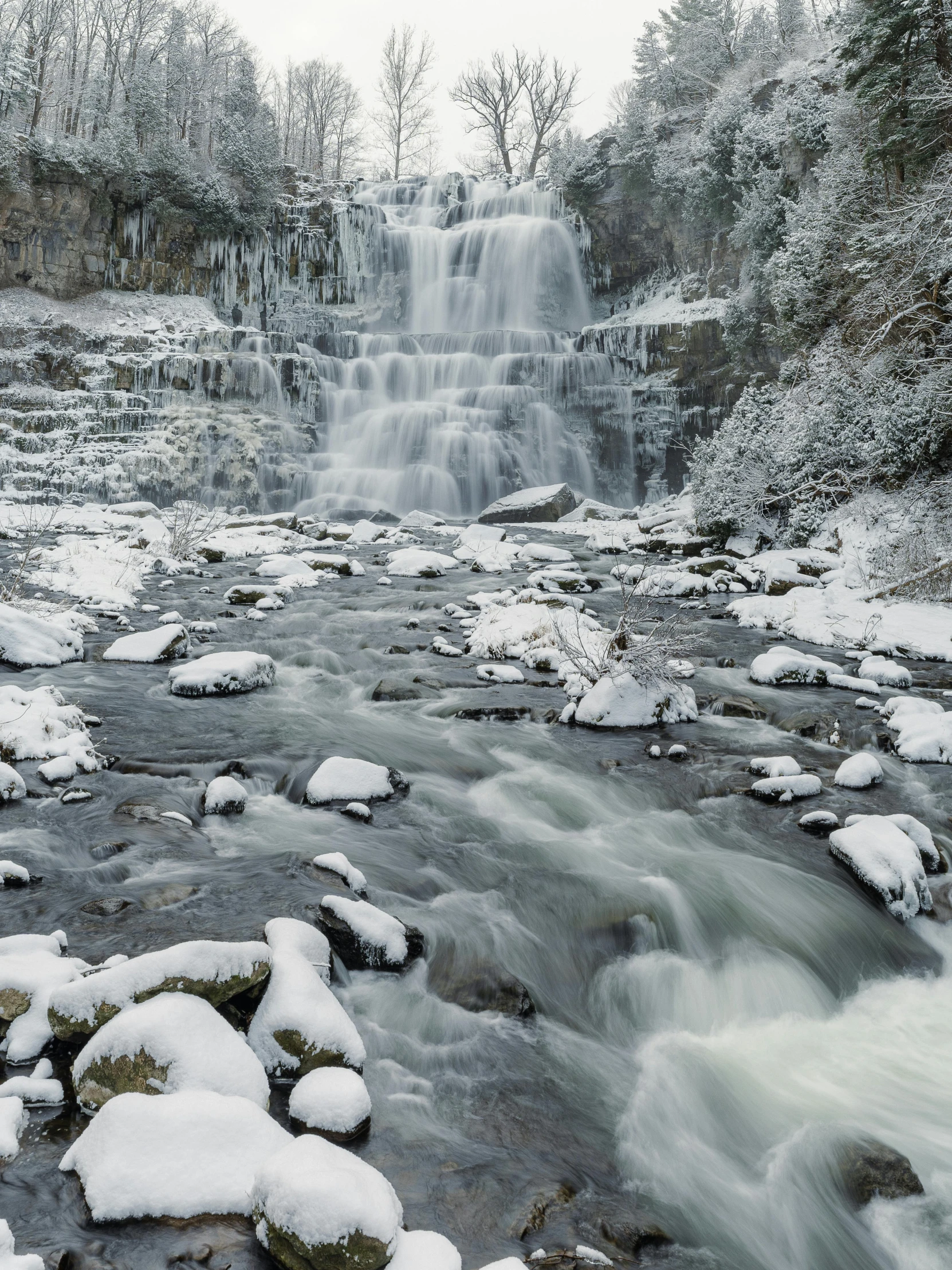 there is a large waterfall surrounded by snow