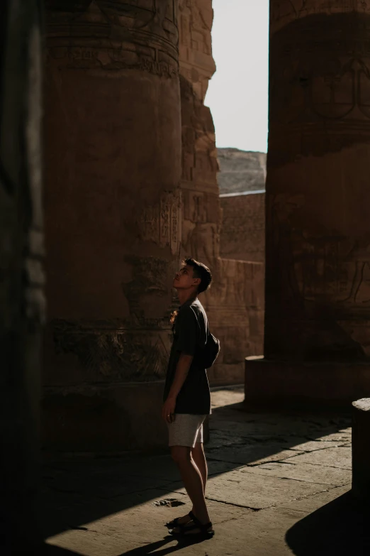 a man standing next to two large pillars