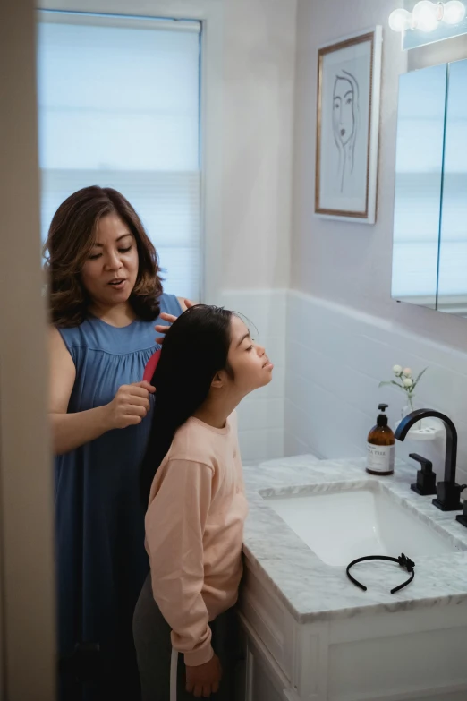 two women standing in front of a sink