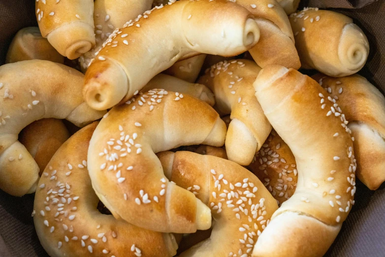 a pile of bread rolls with sesame seed in them