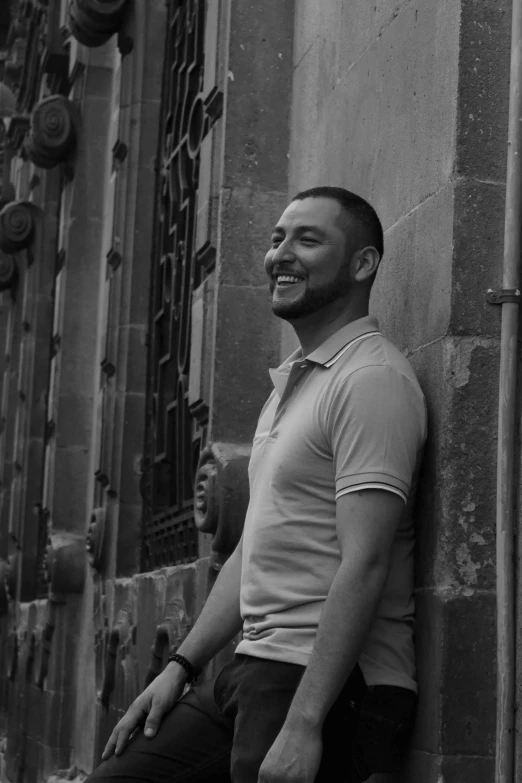 a man sitting against the wall on the street