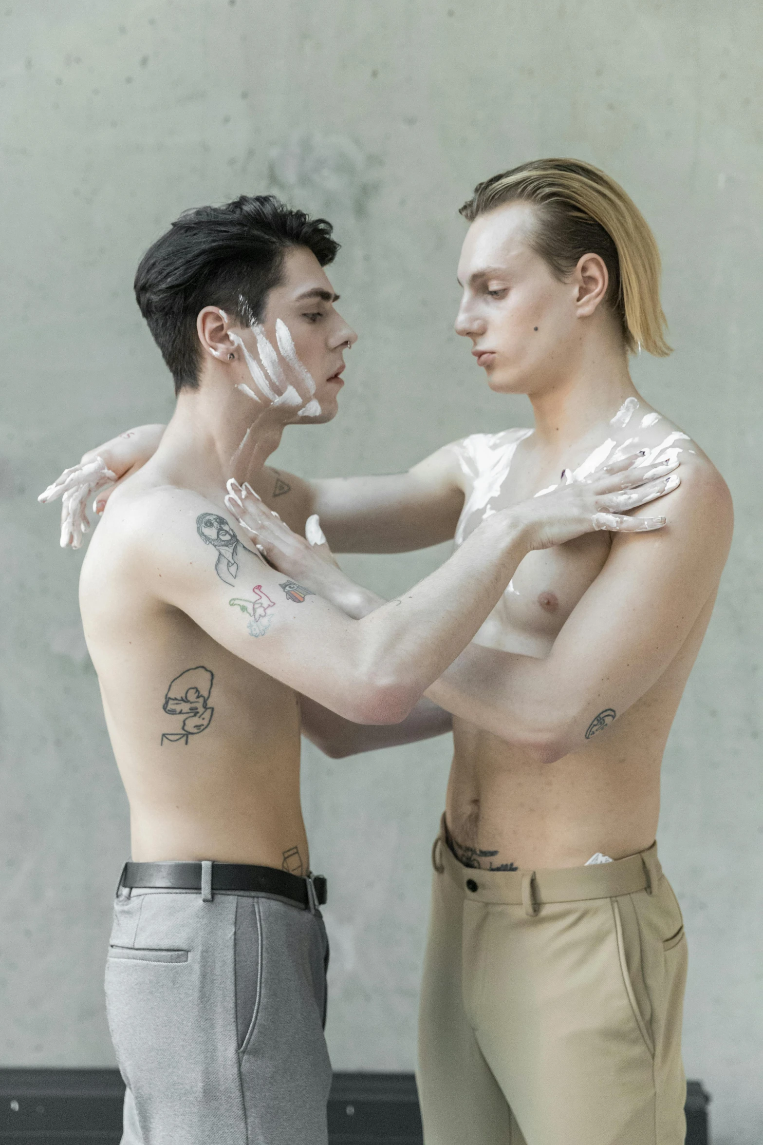 two young men pose with white powder on their faces