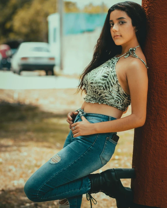 a woman leaning against a pole and looking to the side