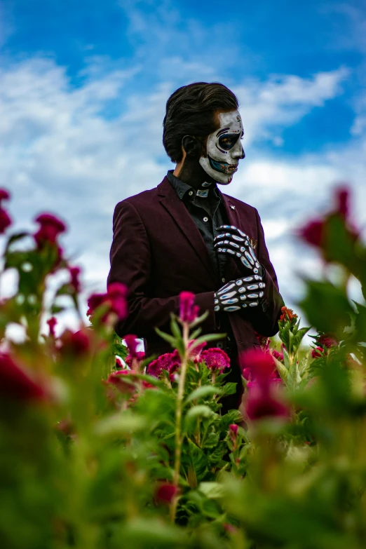 a man wearing face paint while holding a flower