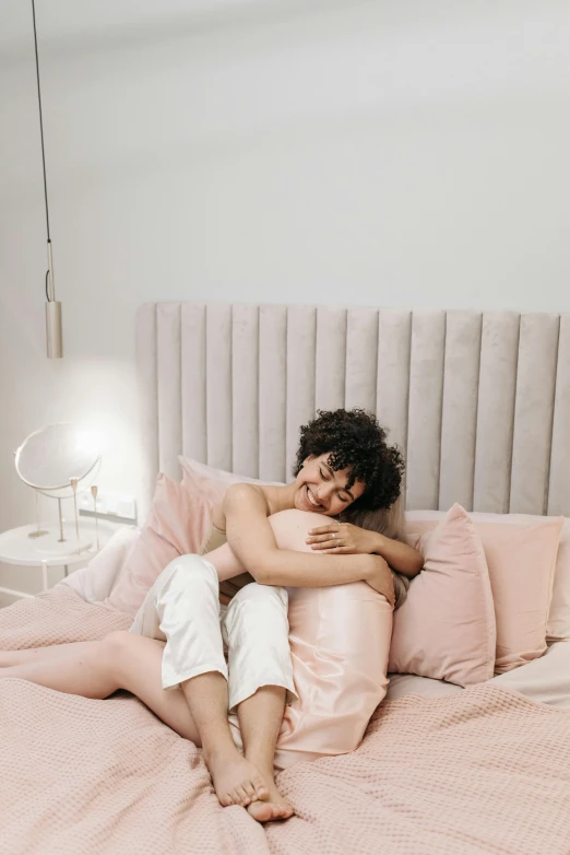 a woman in her pajamas sleeping on the edge of a bed