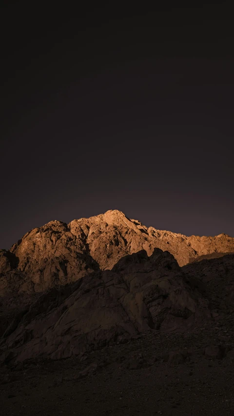 a hill that has a mountain in the background at night