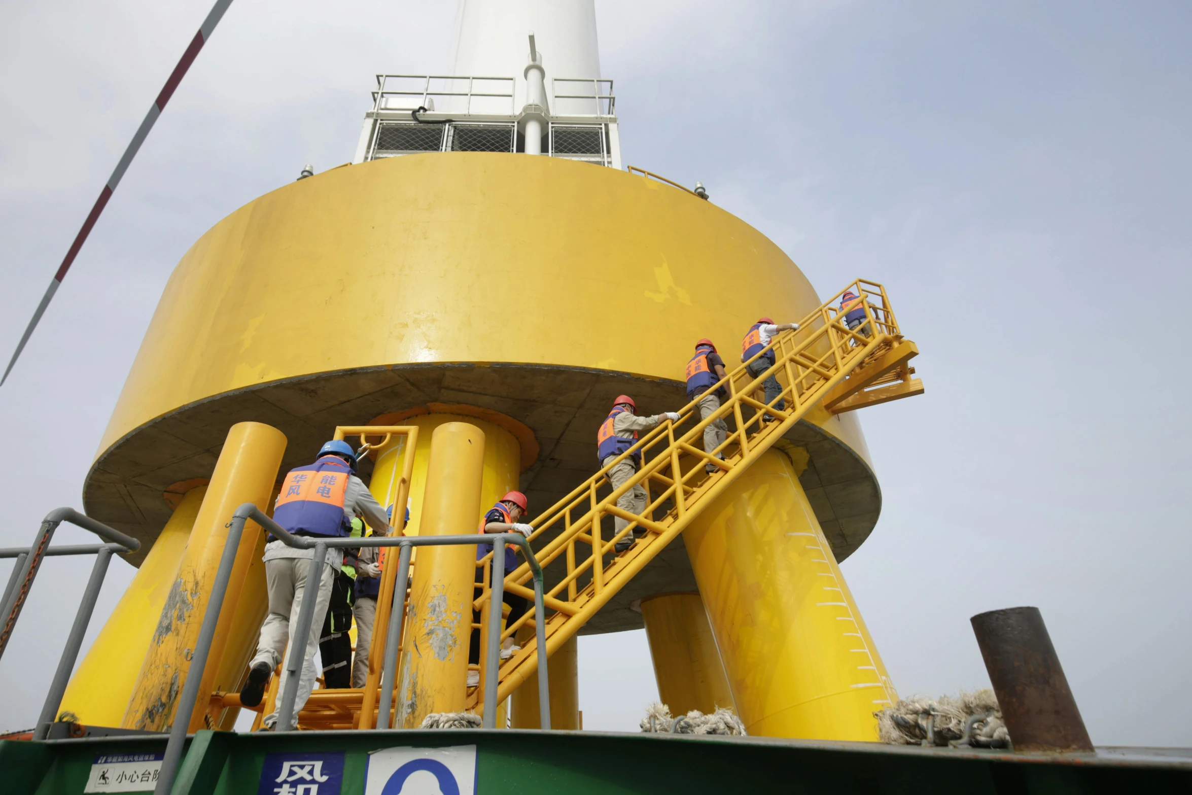 workers on an industrial lift in front of a structure