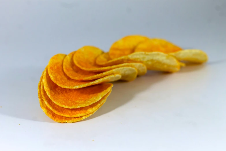 a pile of sliced potato chips sitting on top of a white table